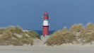 Blick durch die Dünen auf das Leuchtfeuer auf der Ost-Mole