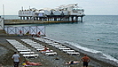 einfacher Kieselstrand mit einer Art von Seebrcke im Hintergrund